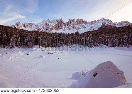 Panoramic View Of Snow Covered Lake Carezza And Latemar In Winter