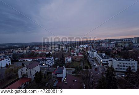 View Of The Western Part Of Ostrowiec Swietokrzyski Just After Sunset. A Dark Sky, Clouds And The La