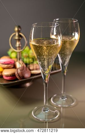 Glasses Of Sparkling White Wine Champagne Or Cava With Bubbles And Sweet Dessert Colorful Macarons B