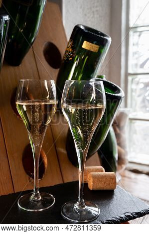 Glasses Of Sparkling White Wine Champagne Or Cava With Bubbles And Classic Wooden Champagne Pupitre