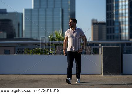 Handsome Man In Fashinable Outfit Walking On City Street. Successful Male Model In Big City Living T