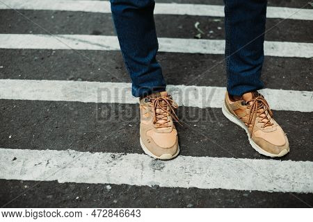 Outfit Of A Man Who Wearing Sneakers And Navy Blue Jeans Standing In Zebra Cross Street