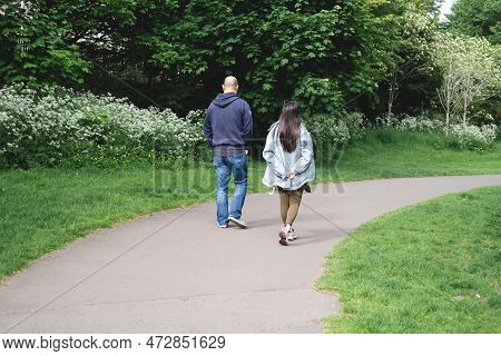 A Multicultural Couple Walking On A Footpath In Figgate Park In Edinburgh In Spring Time. Multiethni