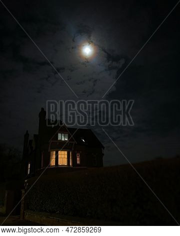 Wondows Glowing In A Mansion At Night Under Full Moon