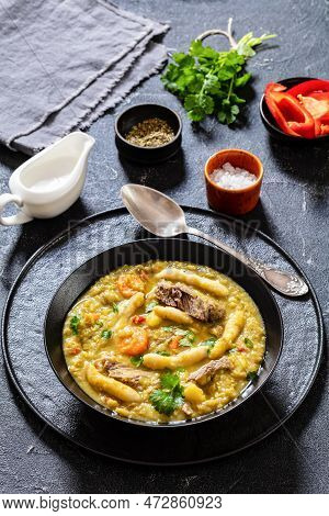 Gungo Peas, Pigeon Peas Soup With Dumplings And Beef In Black Bowl On Concrete Table With Ingredient