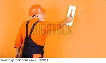 Plastering Tools For Plaster. Plaster Trowel Spatula On Yellow Drywall Plasterboard. Plasterer In Wo
