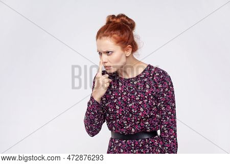 Portrait Of Ginger Woman Wearing Dress Pointing Nose Doing Lie Gesture, Suspecting Trickster In Fals