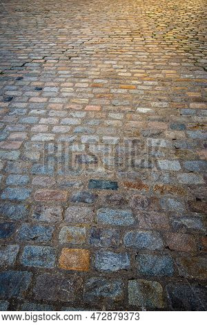 Close Up Of Old Multicoloured Coblestones On Street Pavement With Morning Sun Light Flare Shining Do