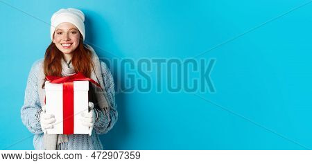 Winter Holidays And Christmas Sales Concept. Cute Redhead Teeanage Girl In Beanie, Sewater And Scarf