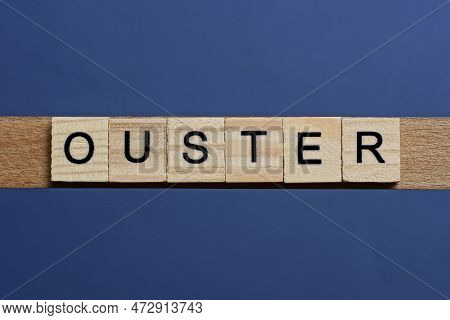 Text The Word Ouster From Brown Wooden Small Letters On A Black Table