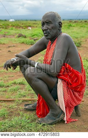 Africa, Kenya, May, 2016 - Portrait Of Old African Men Sitting On A Green Meadow In Masai Tribe Vill