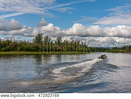 Fairbanks, Alaska, Usa - July 27, 2011: Chena River. Fishing Motor Boat Pulls White Water Line On Bl