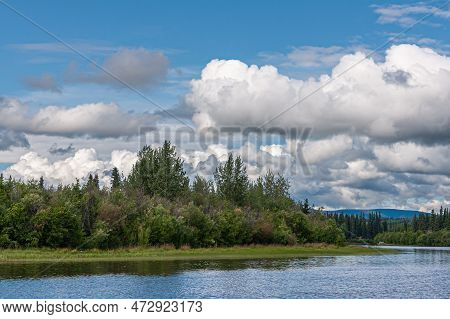 Fairbanks, Alaska, Usa - July 27, 2011: Chena River Up Front Under Blue Cloudscape And Green Forest 