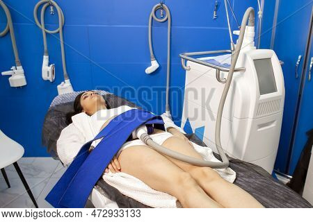 Coolsculpting Procedure In Cosmetology Clinic, The Girl Patient Lies On The Couch Connected To The M