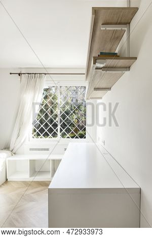 Youth Room With Desk And Bookcase Next To A Window With White Latticework