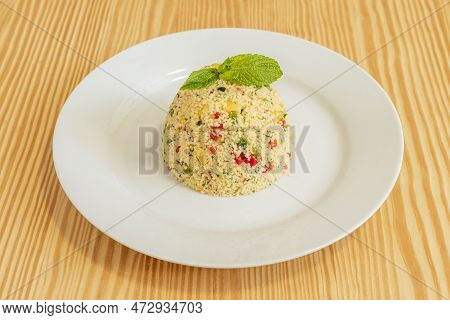 Couscous Taboule With Vegetables And Good Herb On The White Plate.