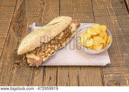 Beef Fillet Pepito With Caramelized Onion, Melted Cheese And French Fries Chips On Wooden Table