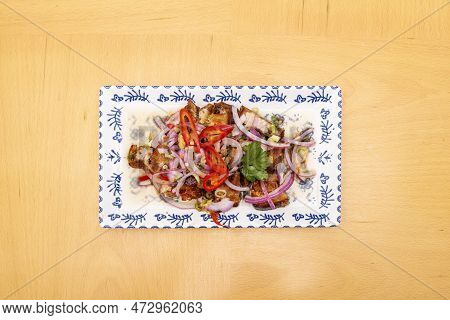Philippine Recipe Of Lechon Ceviche With Peppers And Meat With Raw Purple Onion On Porcelain Plate