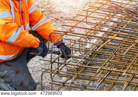 Steel Fixer Assembling Reinforcement Cage Off Rebars. Selective Focus