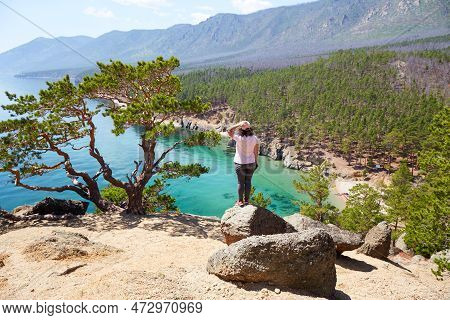 A Female Traveler Enjoys A Beautiful View Of The Lake