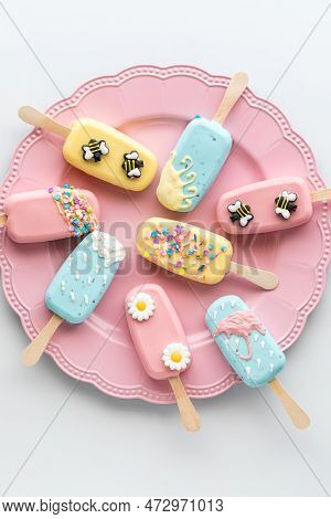 A Pink Platter Topped With Homemade Cakesicles Decorated For Spring.