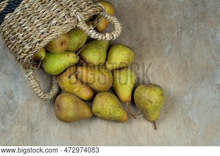 Pears In Basket On A Wooden Background. Fruit Harvest. Autumn Still Life. Pear Variety Bera Conferen