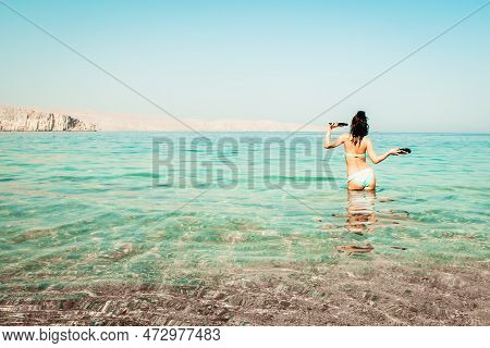 Young Carefree Caucasian Woman Tourist Dance On The Beach In Turquoise Water Alone With Hands Up Hol