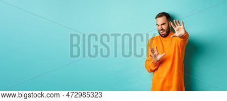 Disgusted Man Cringe And Extending Hands In Protection, Begging For Mercy, Looking At Something With