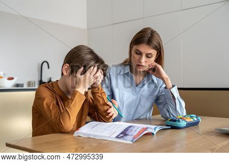 Upset Stressed Child Boy Feeling Frustrated While Doing Homework With Mom At Home. Kid Sitting At Ki