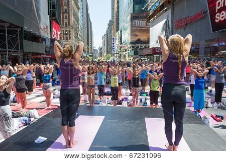 Thousands of New Yorkers are make the first day of summer by practicing yoga in Times Square