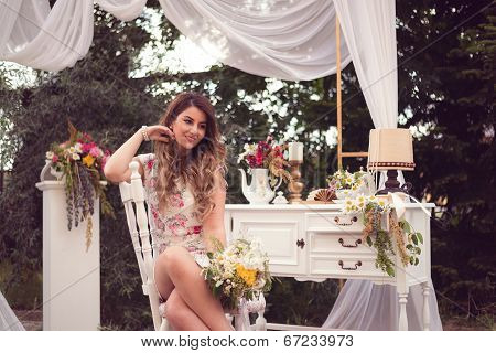Beautiful Woman Sitting On A White Vintage Chair, Holding A Bouquet, In A Shabby Chic, Vintage Decor