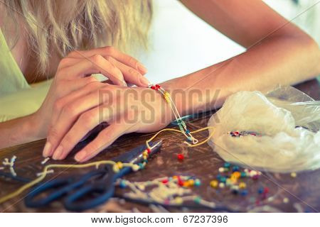 Woman making bracelet at home