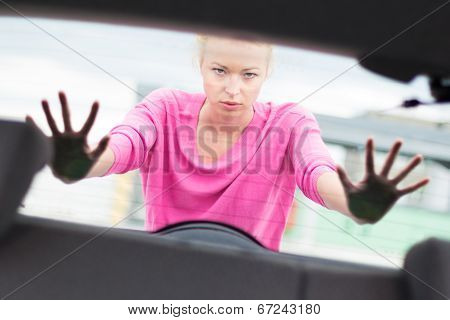 Woman pushing a car.
