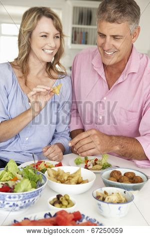 Mid age couple enjoying meal at home