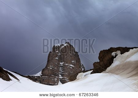 Snowy Rocks And Storm Clouds