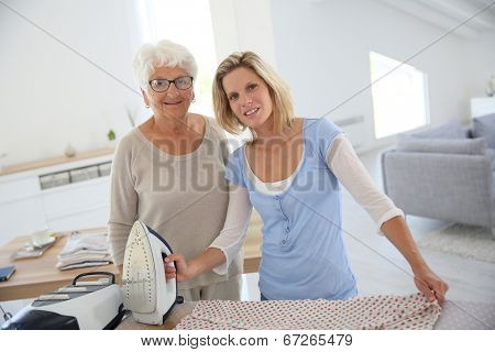 Portrait of senior woman with housekeeper