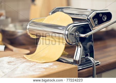 fresh pasta and pasta machine on kitchen table