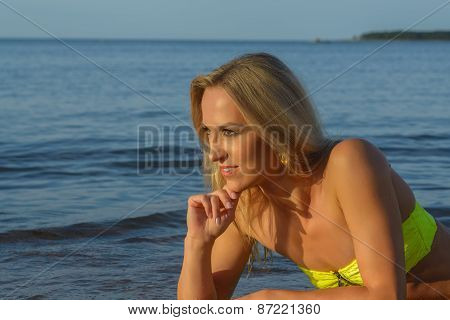 young woman in green bikini posing on a beach