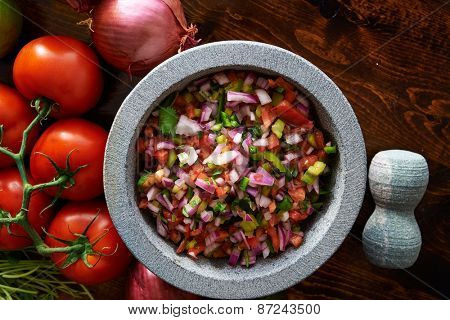 fresh mexican pico de gallo salsa in stone molcajete shot top down