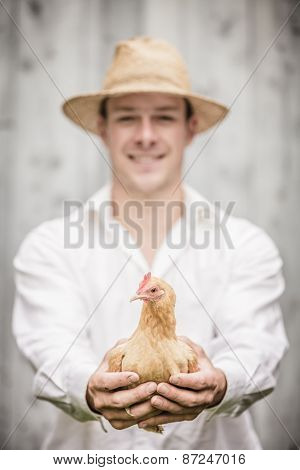 Farmer Holding A Beige Chicken