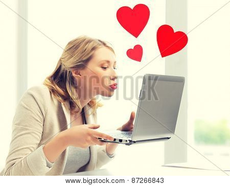 virtual relationships, online dating and social networking concept - woman sending kisses with laptop computer