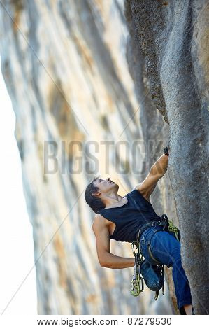 Rock climber climbing up a cliff