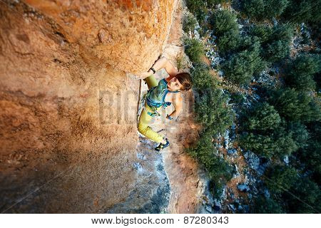 Rock climber climbing up a cliff
