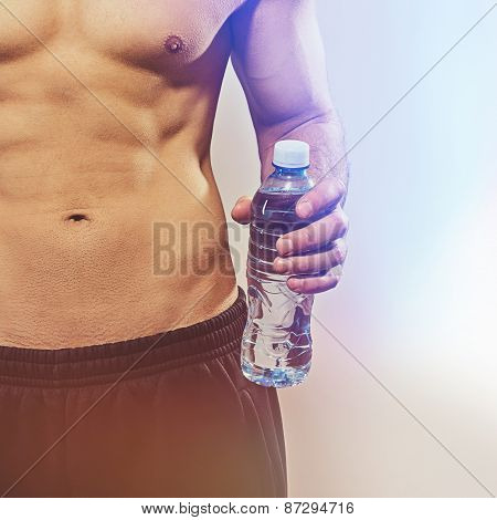 Closeup of fit young man holding bottle of water