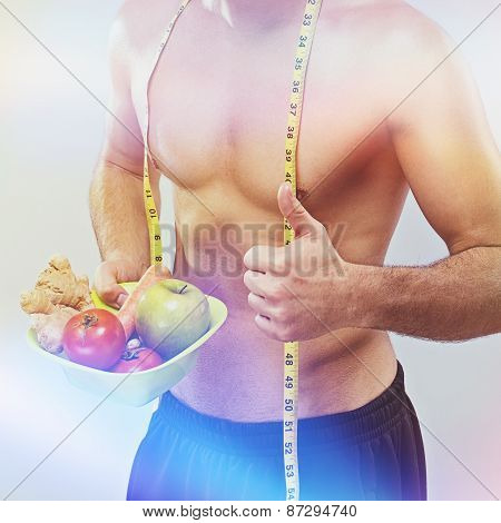 Fit shirtless guy with fresh fruits and vegetables