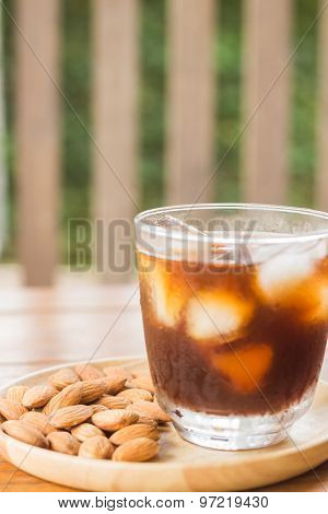 Glass Of Black Iced Coffee With Almond Grain
