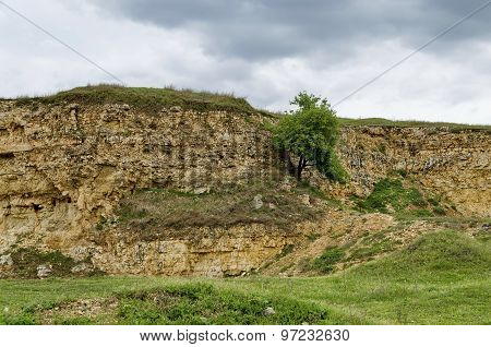 General view toward crag of sedimentary rock in the field