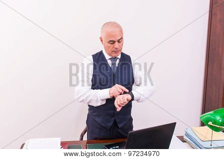A Businessman Uses Smartwacth Pic, At Desk, At Work.