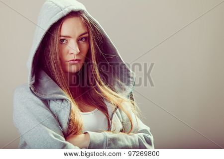 Pensive Teenager Girl In Hood Crossing Arms.