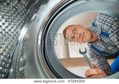 Repairman Looking Inside The Washing Machine